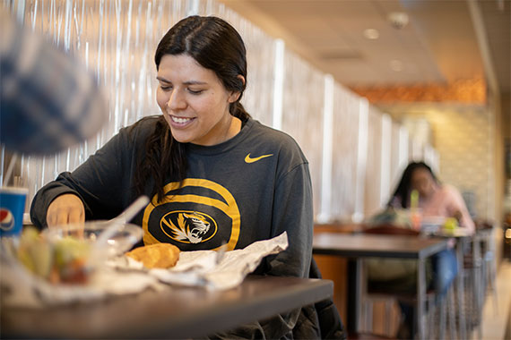 Female student eating at campus dining hall