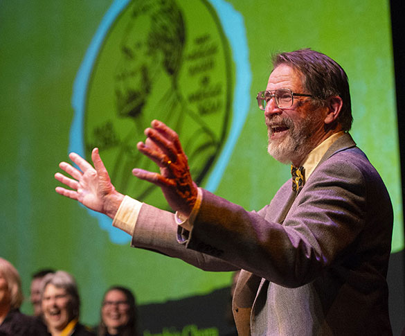 George Smith on stage with Nobel Medal illustration in background