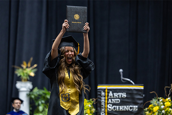 Student holds up degree