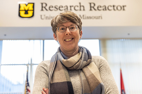 Heather Hennkens in a scarf and standing with arms crossed