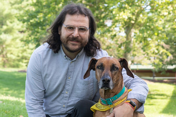 Man kneeling with around a dog