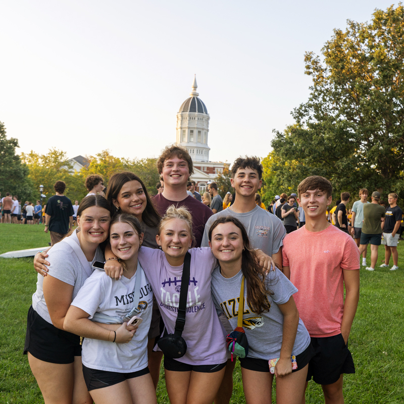 Group of students posing for a picture with Jesse Hall in the background