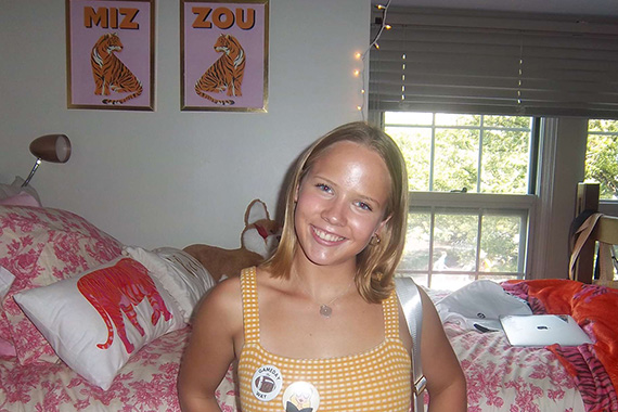 Student smiling in a dorm room decorated in Mizzou Tigers decor