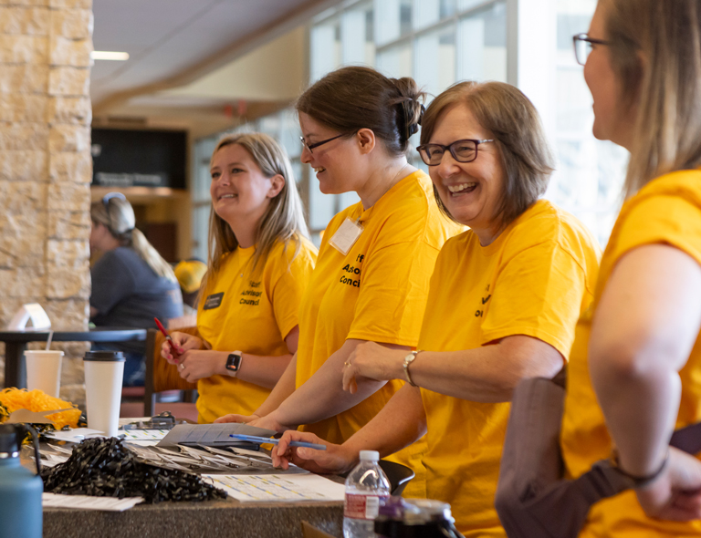 Staff standing at a counter laughing