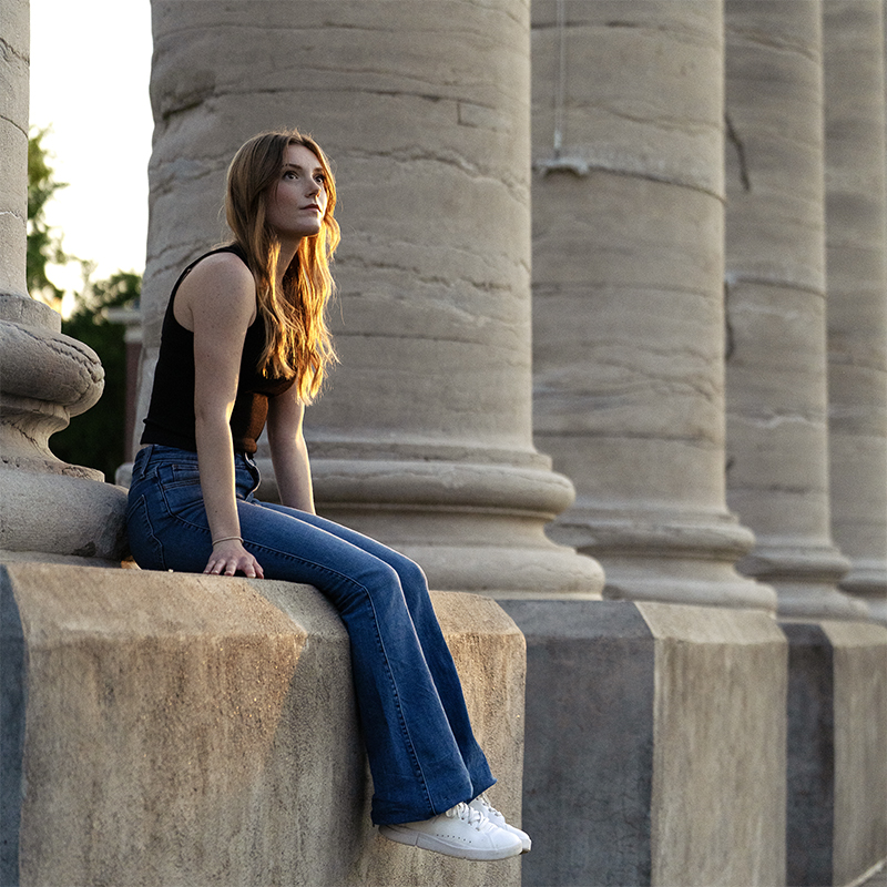 Student sitting at the base of the columns on the Mizzou Quad