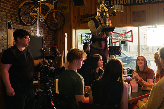 Film crew filming a group of students