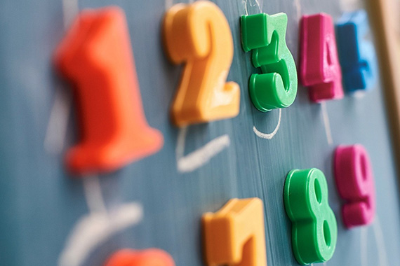 Close-up view of magnets in the shape of numbers on a blackboard