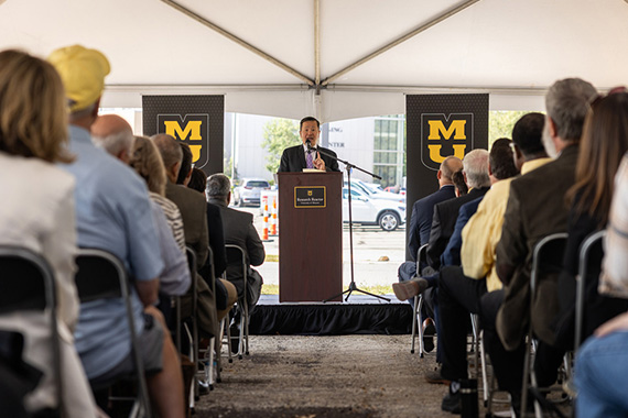 Man speaking at a podium in front of a crowd