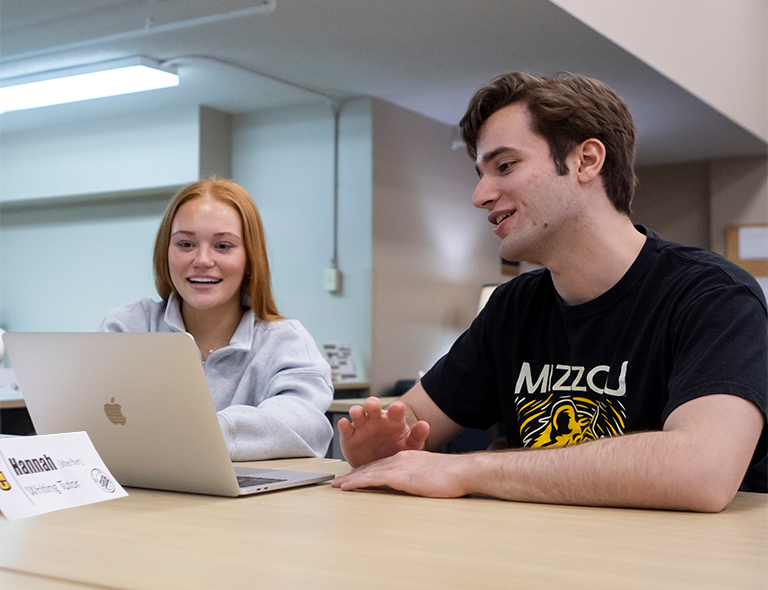 A writing tutor helping a student with a paper in the Mizzou Writing Center