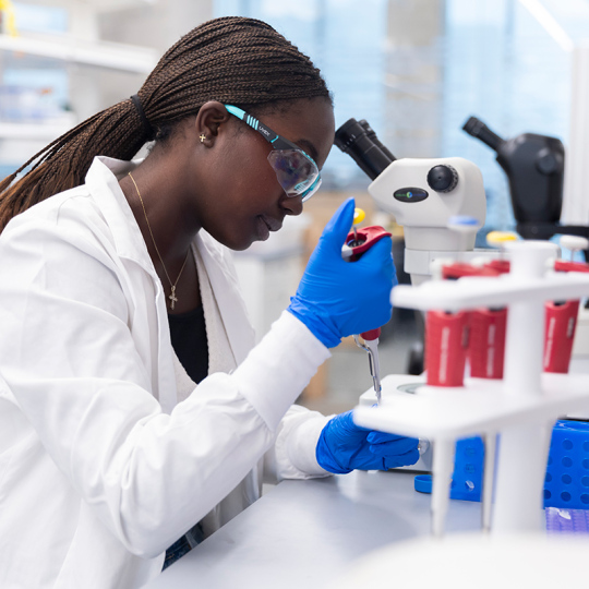 Janet Musangali working in a lab doing research.