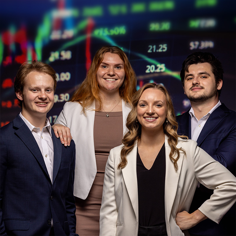 Mizzou students standing in front of a stock ticker