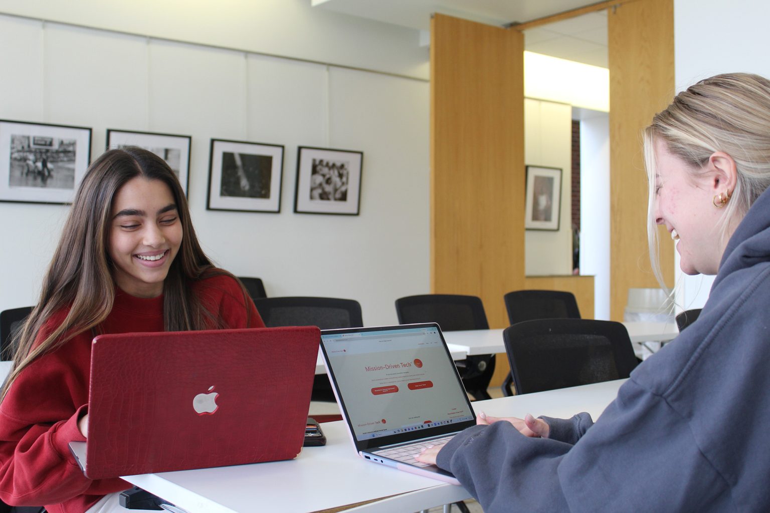 Two students working at their laptops